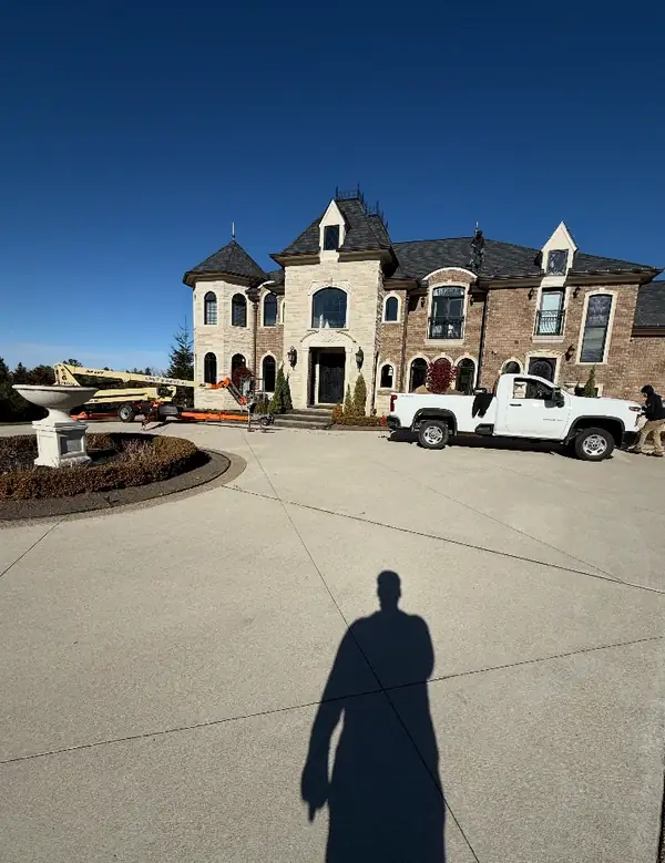 A large estate home with a lift and the crew truck in the driveway, ready to install.