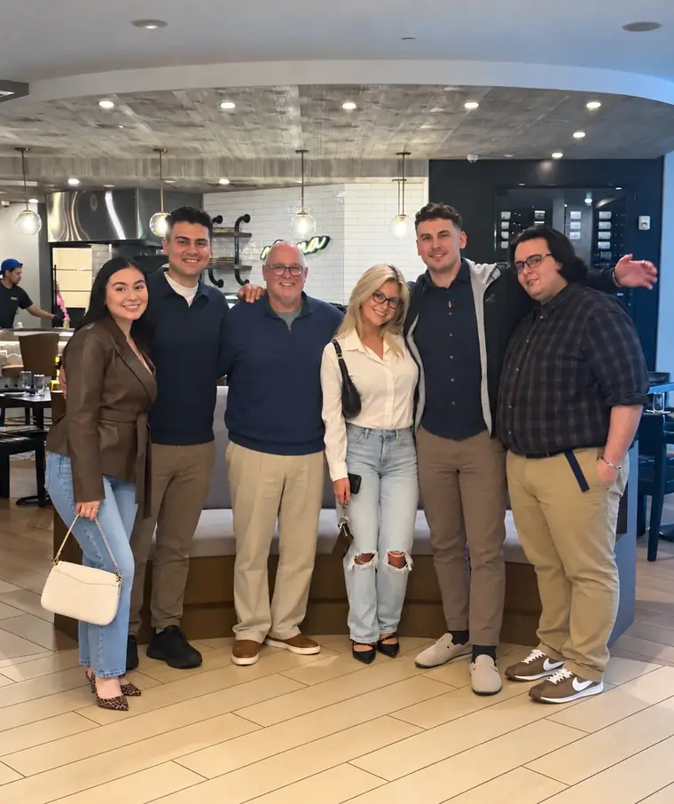 The Dynamite Lights team, six people, smiling together in a restaurant.